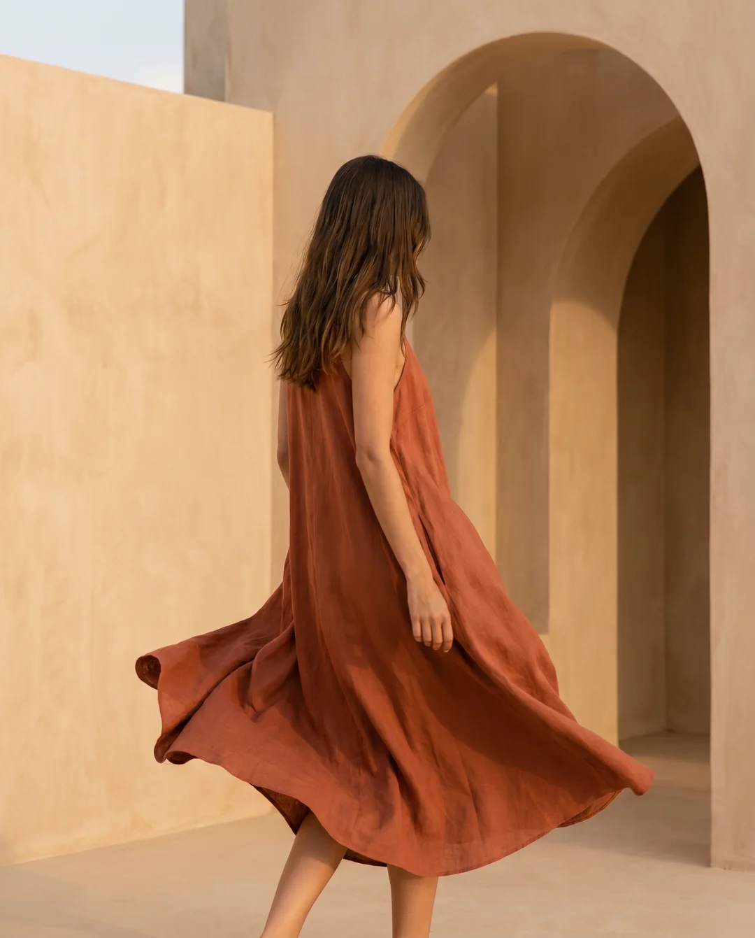 Peça de moda gerada pela Donna a partir de um prompt: vestido de linho terracota em movimento